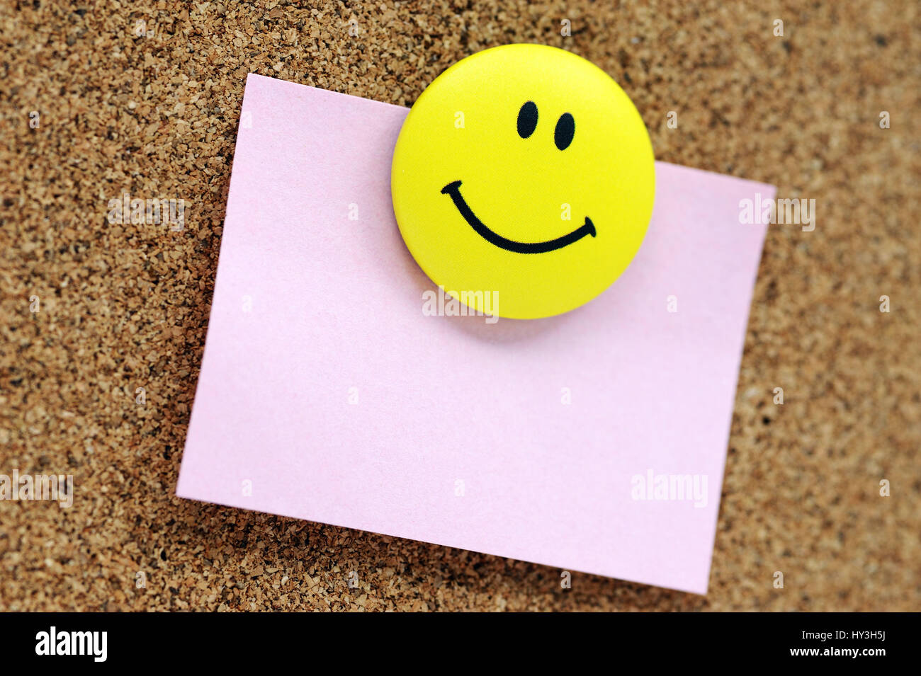 Striscia di carta con Smiley in un Pinwand, Zettel mit Smiley un einer Pinwand Foto Stock