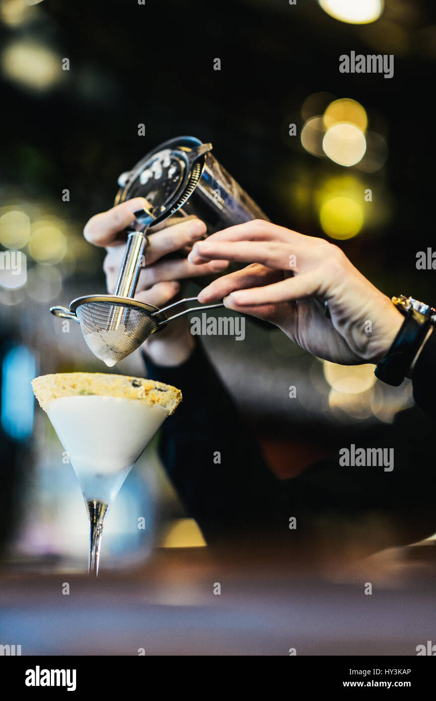 Bar setacciatura di gara un cocktail in un bicchiere Foto Stock