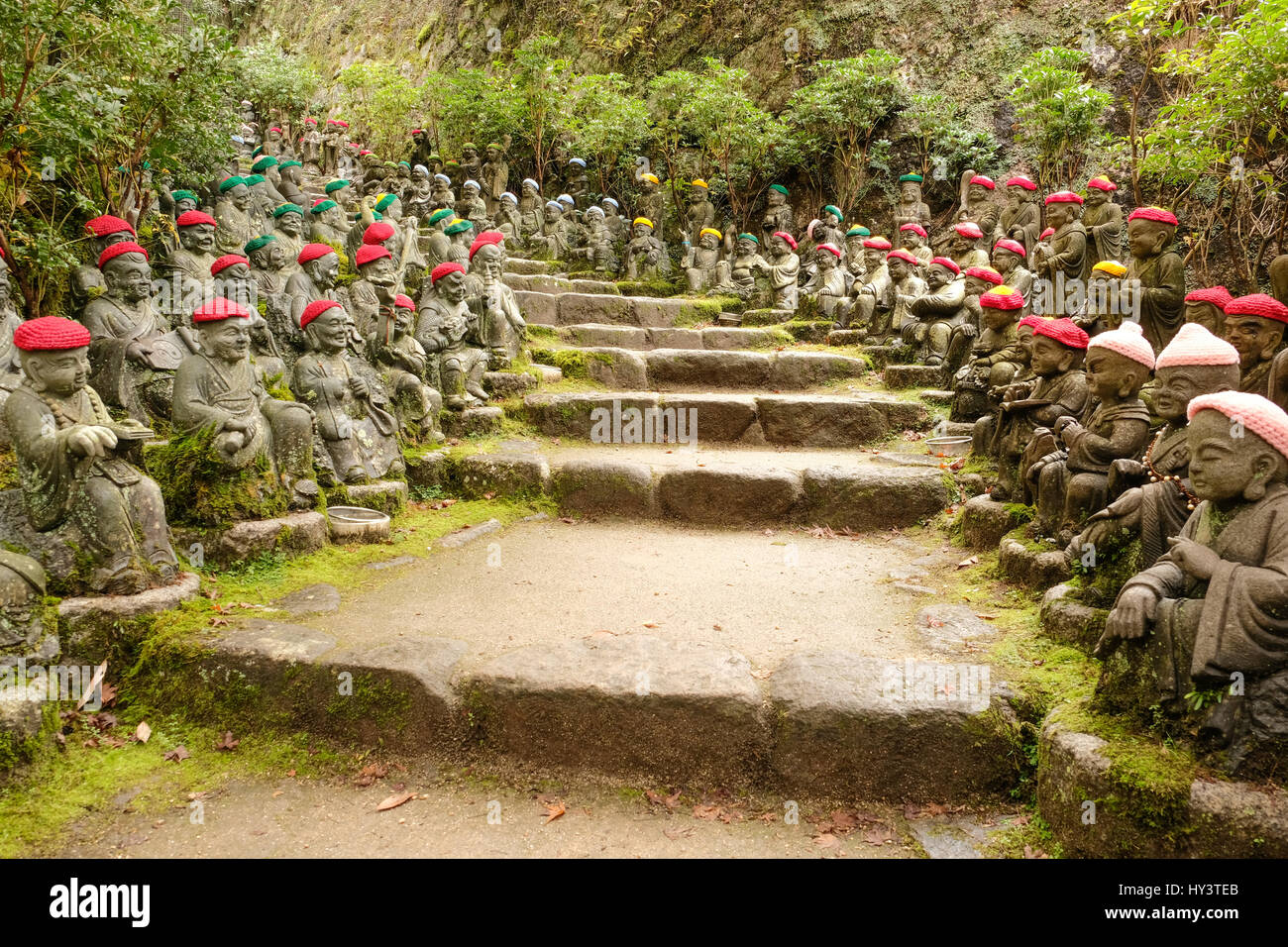 Jizo statue con colorati lavorati a maglia cappelli sedersi su entrambi i lati dei gradini di pietra in Daisho-nel tempio di Miyajima, Giappone Foto Stock