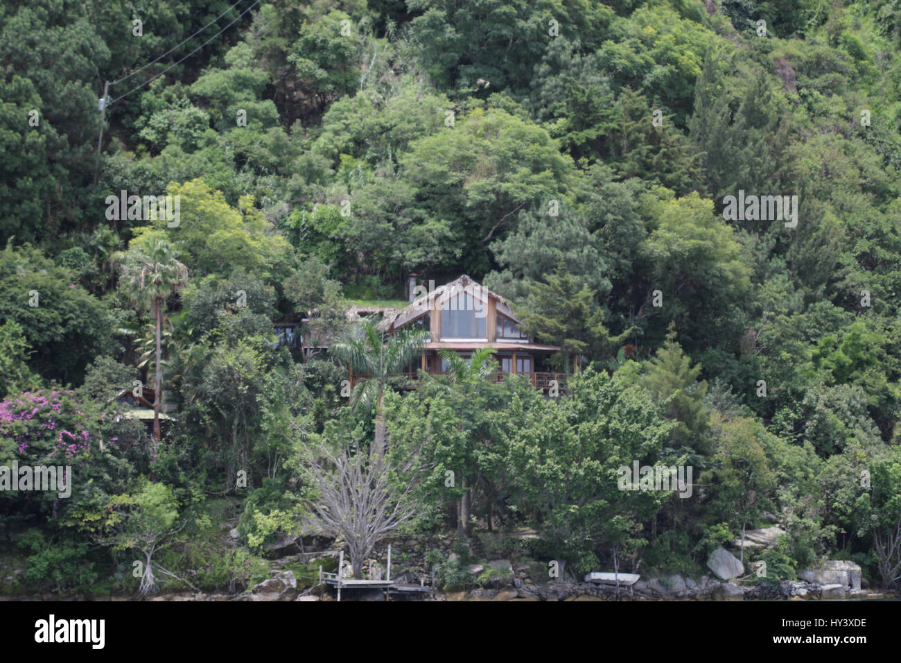 Moderno e ricco di persone case costruite accanto al lago sulla ripida montagna Foto Stock