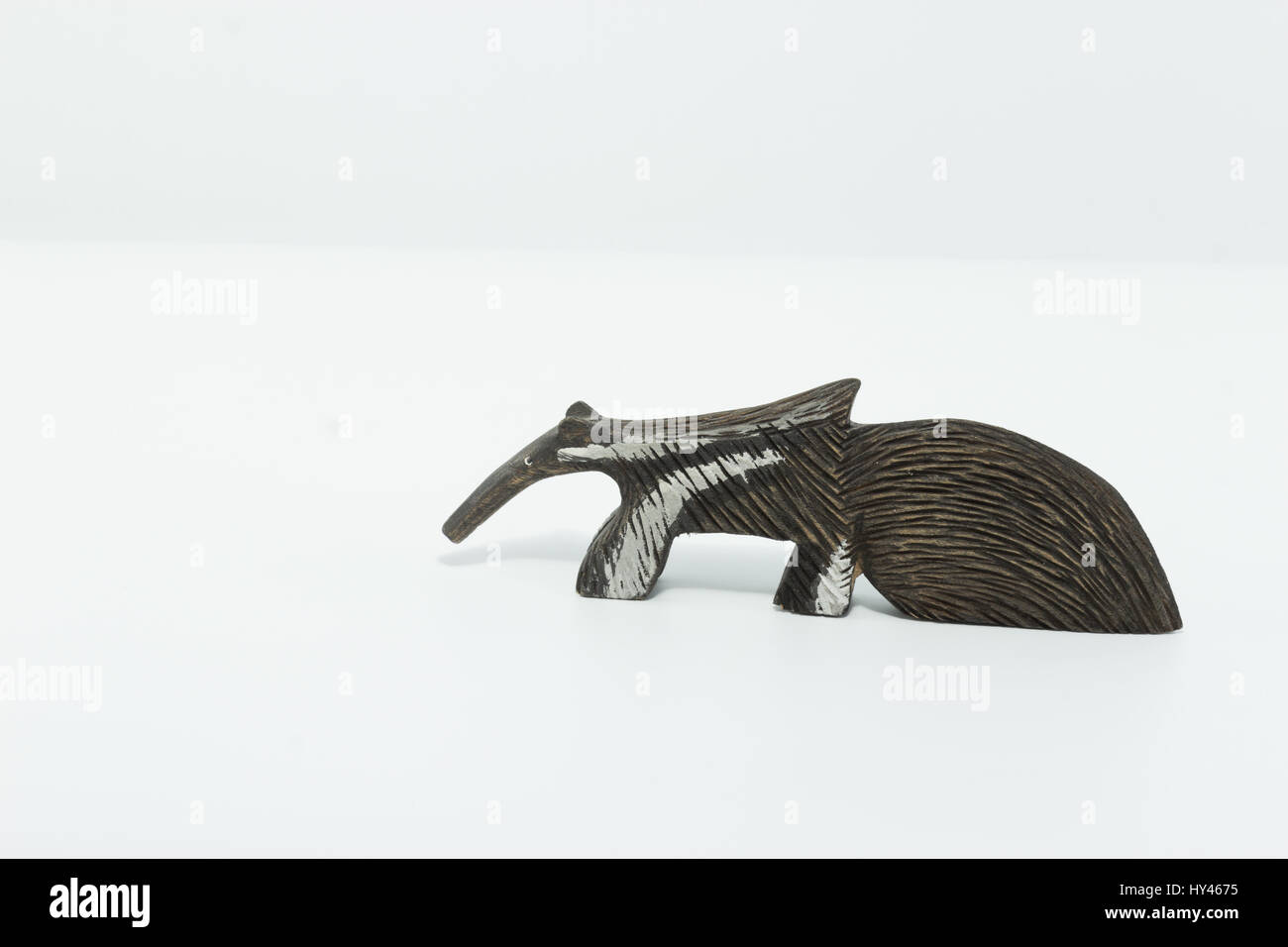 Anteater - tamanduá bandeira - scolpito su legno isolato in uno sfondo bianco Foto Stock