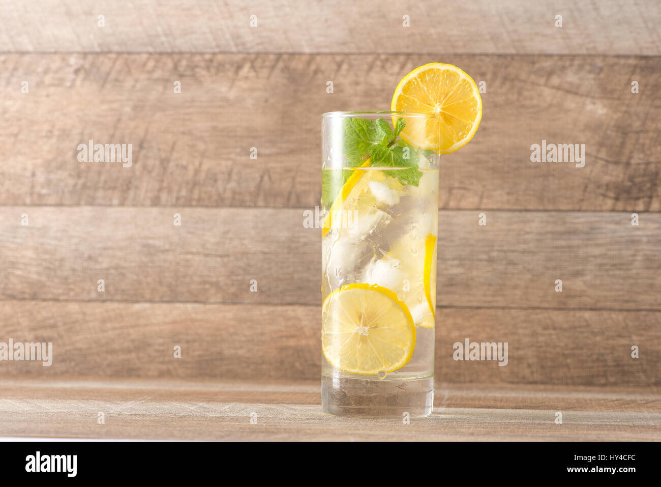 Bere per le calde giornate estive. Lime fresco e limone Limonata con la menta in un bicchiere su una scrivania in legno Foto Stock