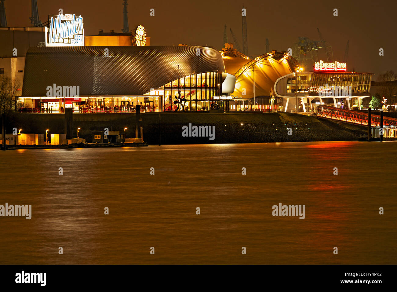 Vista sul fiume Elba (fiume) Stadio illuminato "Teatro tage im Hafen Hamburg' di Amburgo in serata, Foto Stock