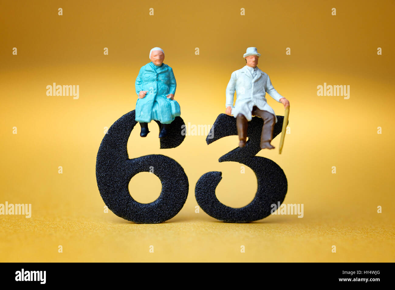 Senior Citizen's coppia sul numero 63, simbolico foto pensione all'età di 63 anni, Seniorenpaar auf der Zahl 63, Symbolfoto Rente mit 63 Jahren Foto Stock