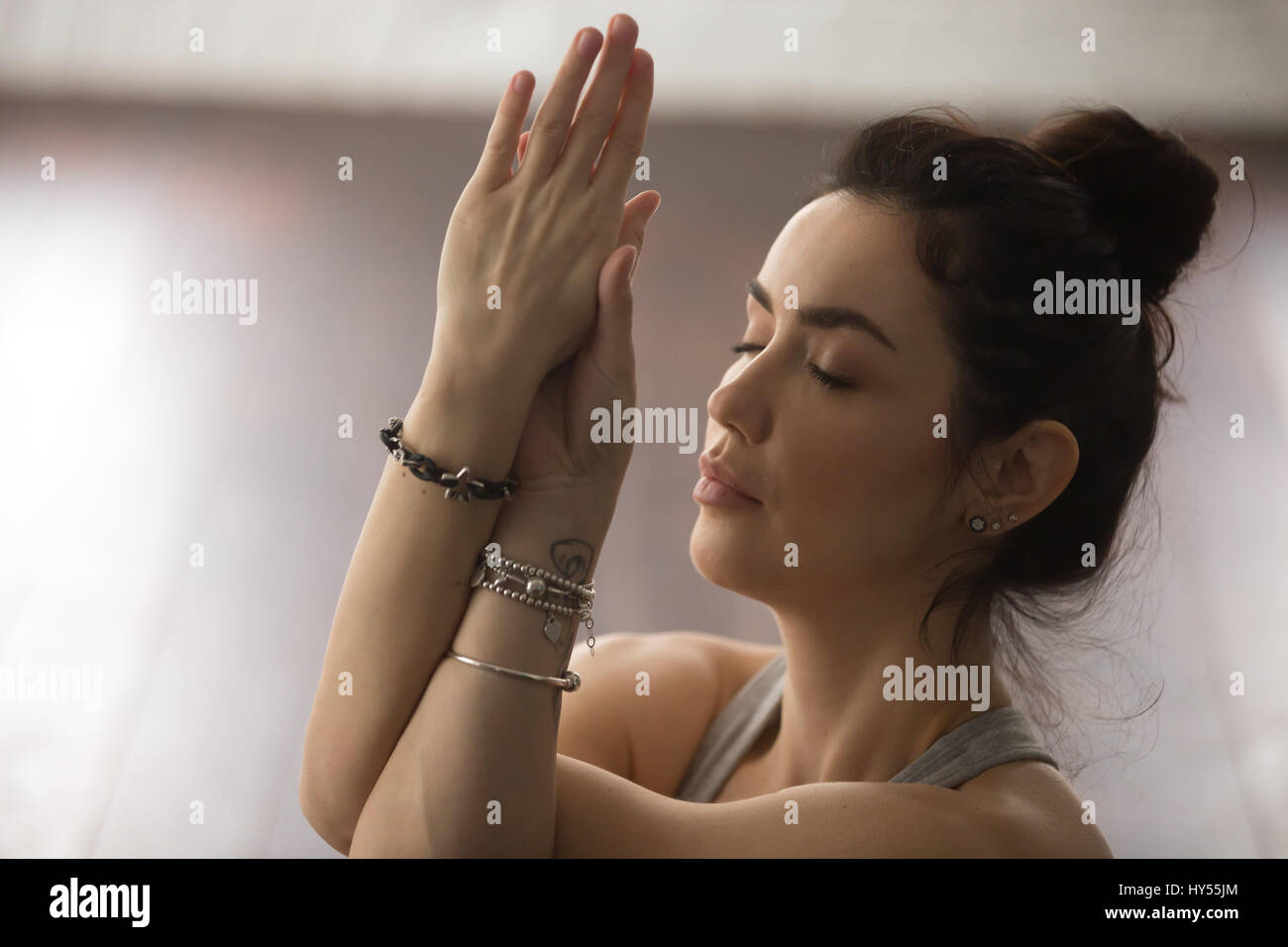 Ritratto di giovane donna attraente meditando con gli occhi chiusi, Foto Stock