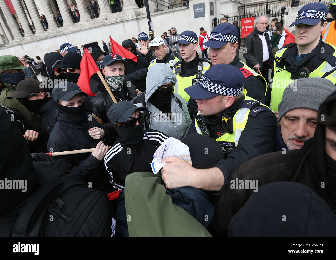 UAF (Unite contro il fascismo)dimostranti bagarre con gli ufficiali di polizia a Trafalgar Square a Londra, durante una counterprotest contro la Gran Bretagna prima e EDL (Inglese difesa League) marche. Foto Stock