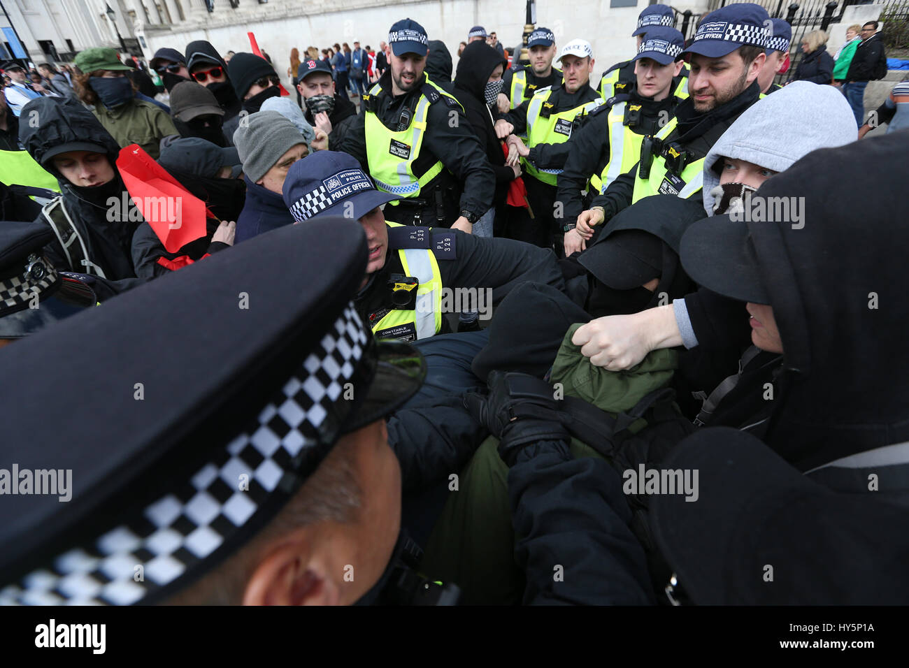 UAF (Unite contro il fascismo)dimostranti bagarre con gli ufficiali di polizia a Trafalgar Square a Londra, durante una counterprotest contro la Gran Bretagna prima e EDL (Inglese difesa League) marche. Foto Stock