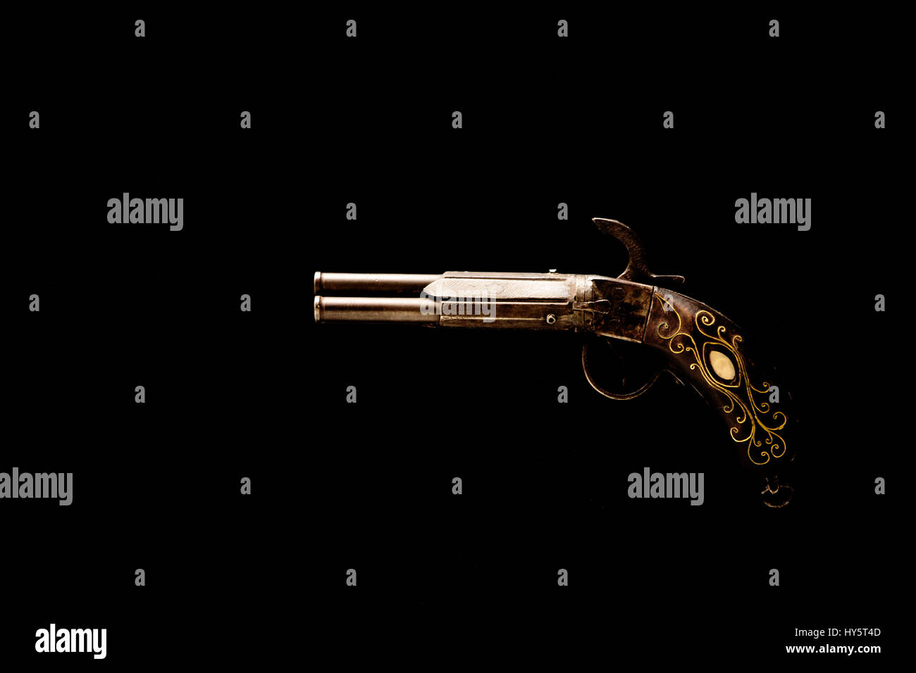 Una pistola di antiquariato, oggetti decorativi, su sfondo nero Foto Stock