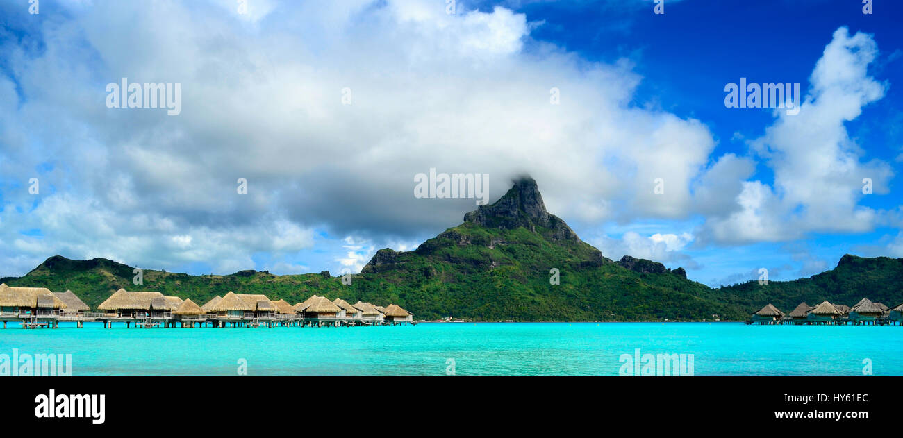 Immagine di panorama di un tropicale Bora Bora paesaggio con verde monte Otemanu dietro un resort di lusso in laguna turchese dell'isola vicino a Tahiti Foto Stock