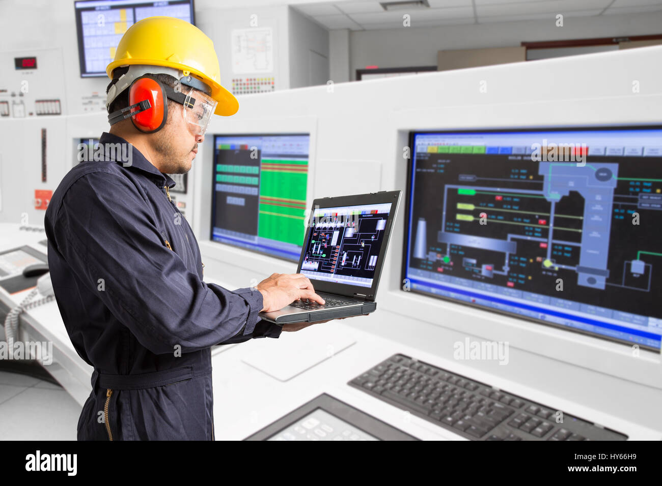 Ingegnere elettrico funzionante a sala di controllo di una moderna centrale termica Foto Stock