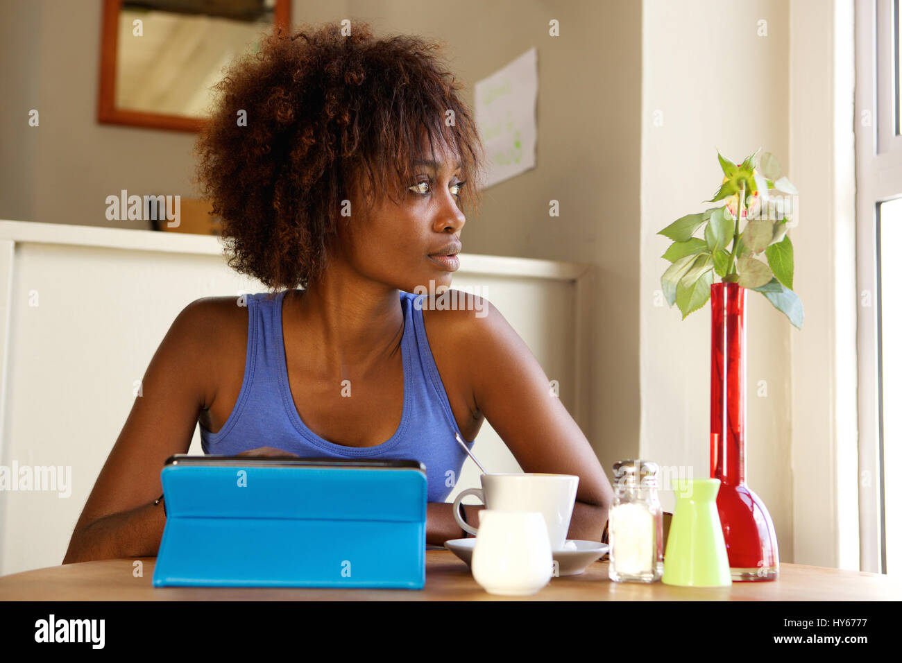 Ritratto di un attraente donna africana con tavoletta digitale presso il cafe Foto Stock