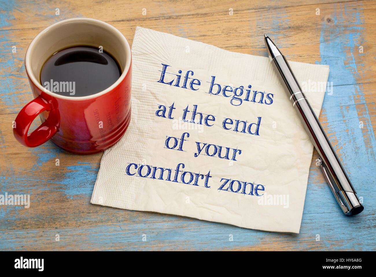 La vita inizia alla fine della vostra zona di comfort - grafia di ispirazione su un tovagliolo con una tazza di caffè Foto Stock