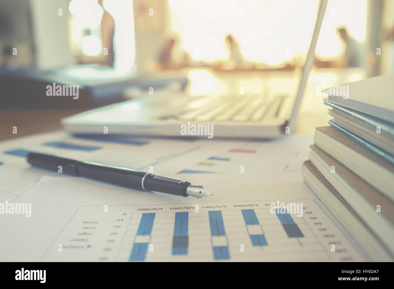 Il concetto di business con copia spazio. Scrivania da ufficio tabella con penna focus e grafico analisi, computer, notebook, una tazza di caffè sulla scrivania.tono Vintage retrò fi Foto Stock