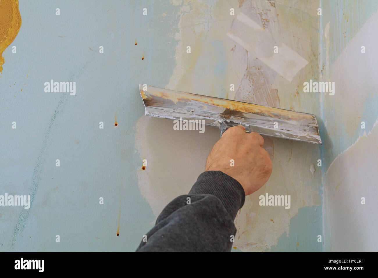 Master rende le riparazioni in appartamento e il rivestimento delle pareti con parete di putty putty per difettoso Foto Stock