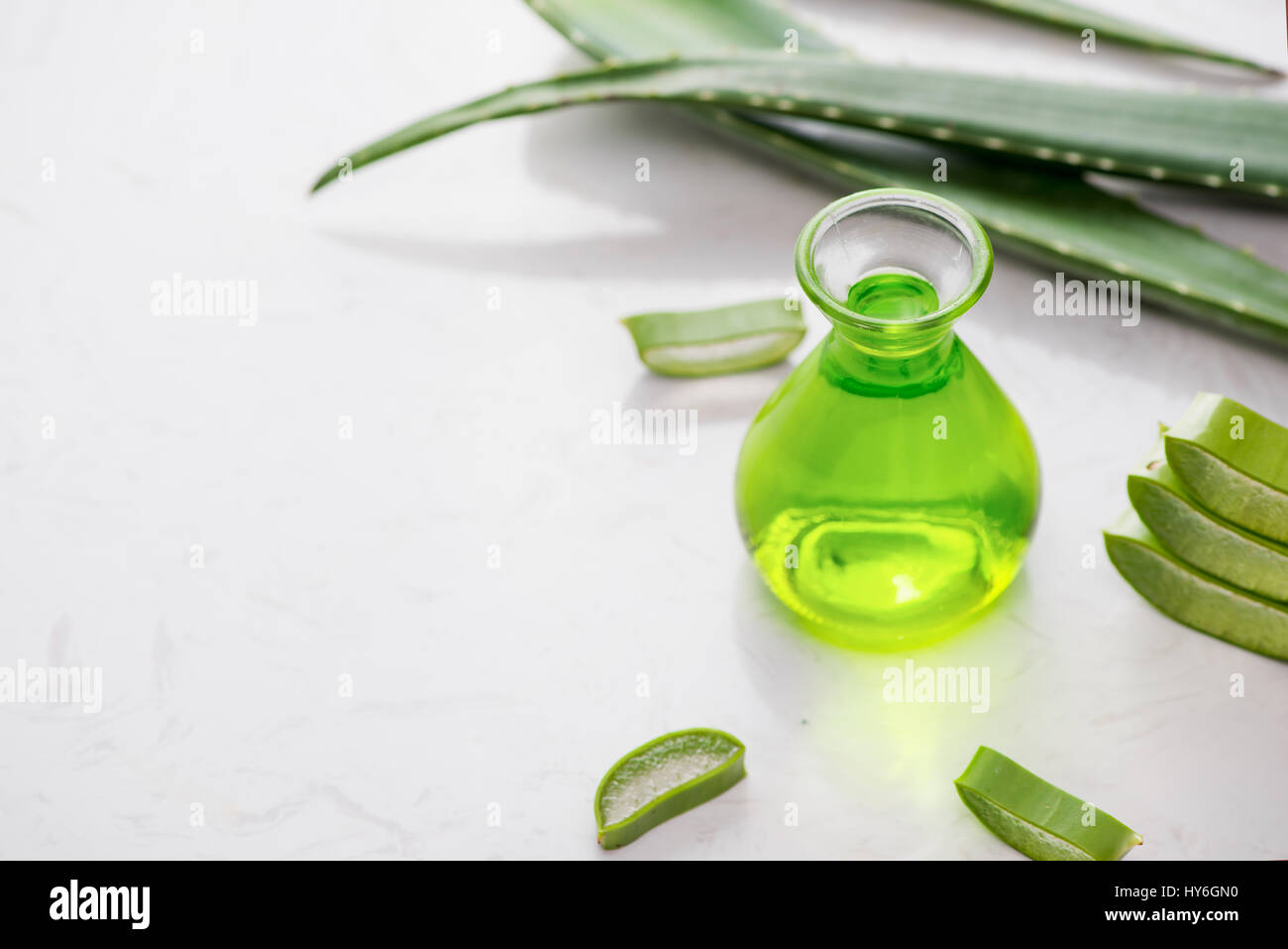 Aloe vera olio essenziale e Aloe foglie su uno sfondo bianco. Foto Stock