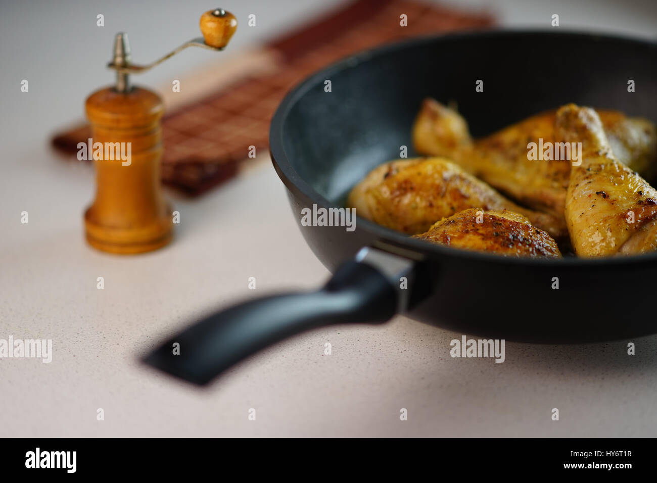 Fritto delizioso le cosce di pollo in una padella sul tavolo Foto Stock