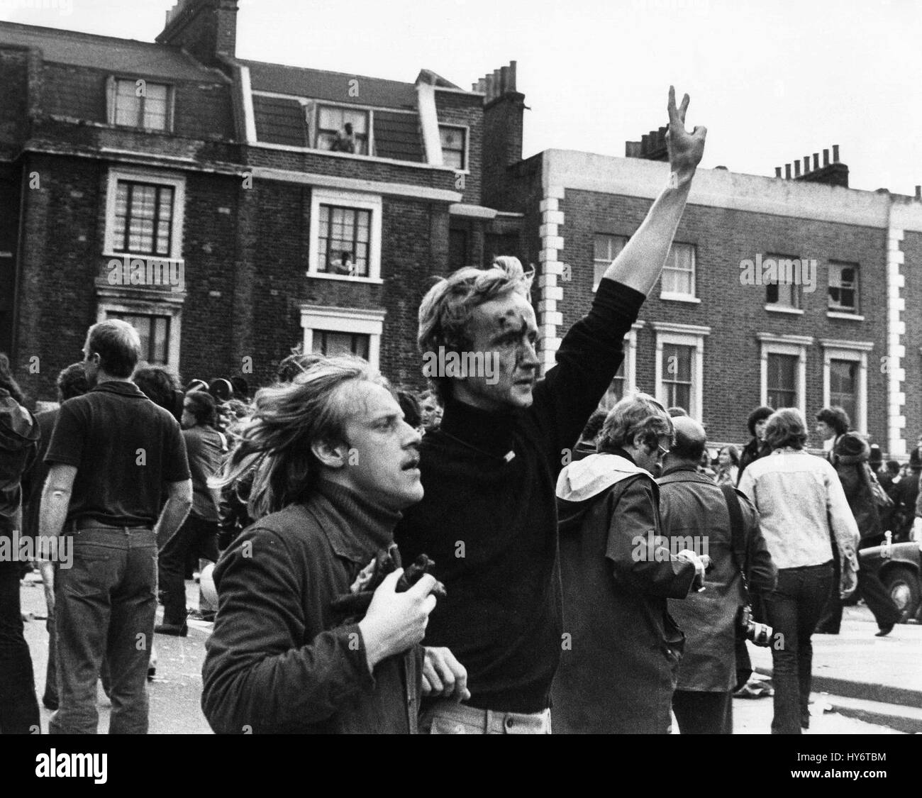 Un uomo ferito è aiutato via durante gli scontri tra manifestanti e un Front National Party marzo attraverso Brixton a Londra in Inghilterra circa 1977. Foto Stock