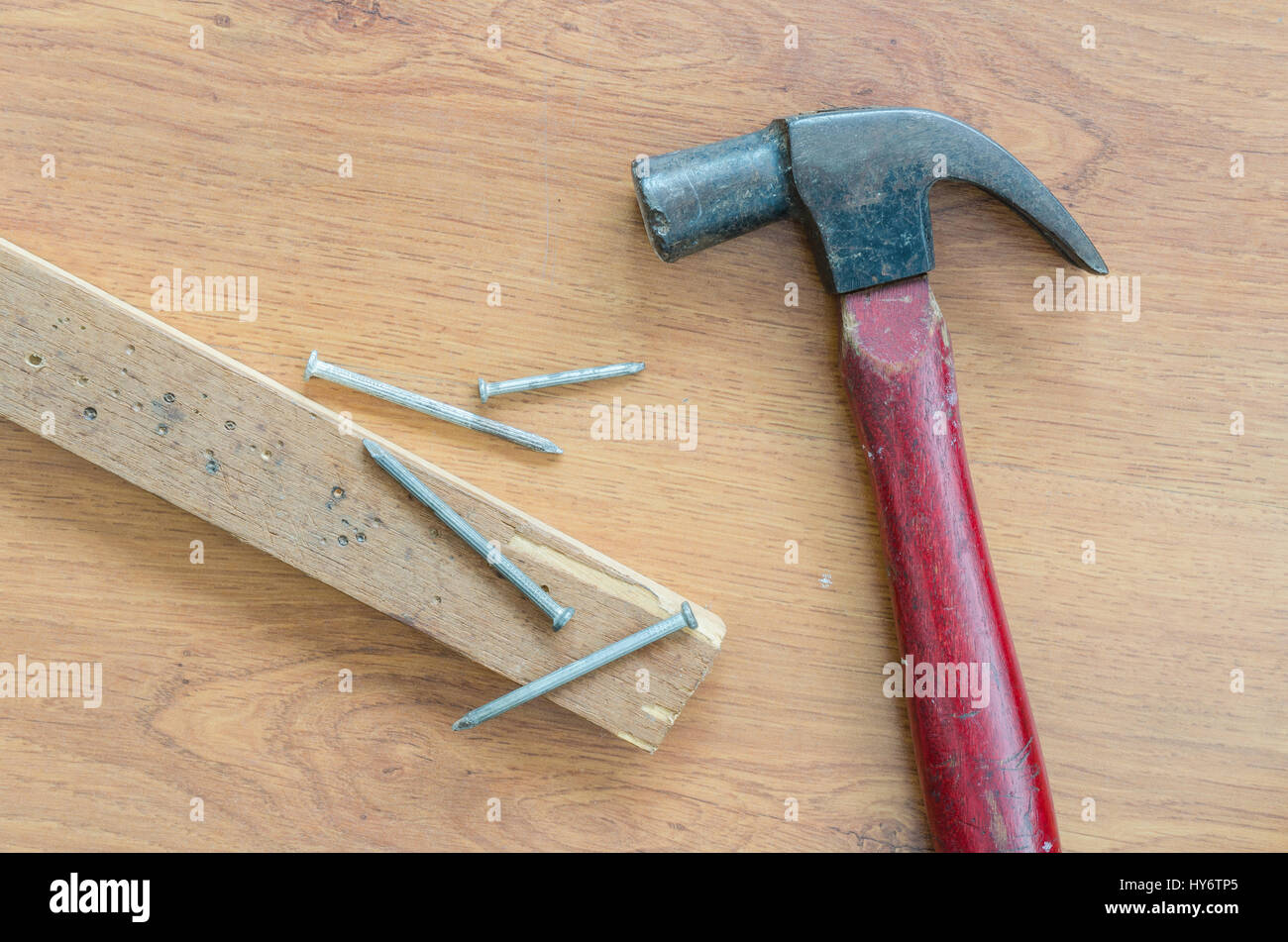 Vecchio maglio chiodi e legno su tavola Foto Stock