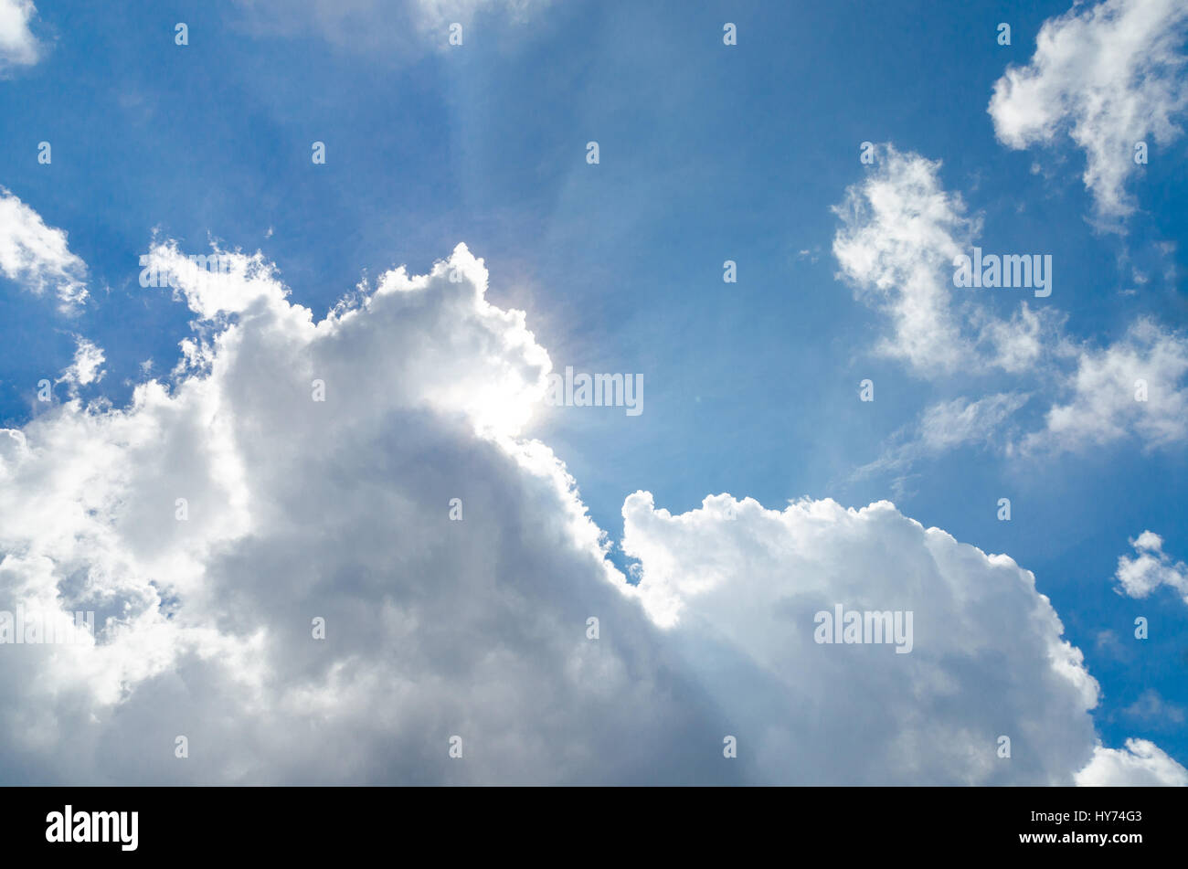 Sun dietro il cloud e cielo blu Foto Stock