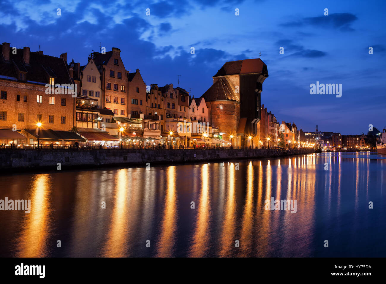 Città Vecchia di Danzica skyline notturno in Polonia, storico case mercantili, gru, luci della città la riflessione sul fiume Motlawa Foto Stock