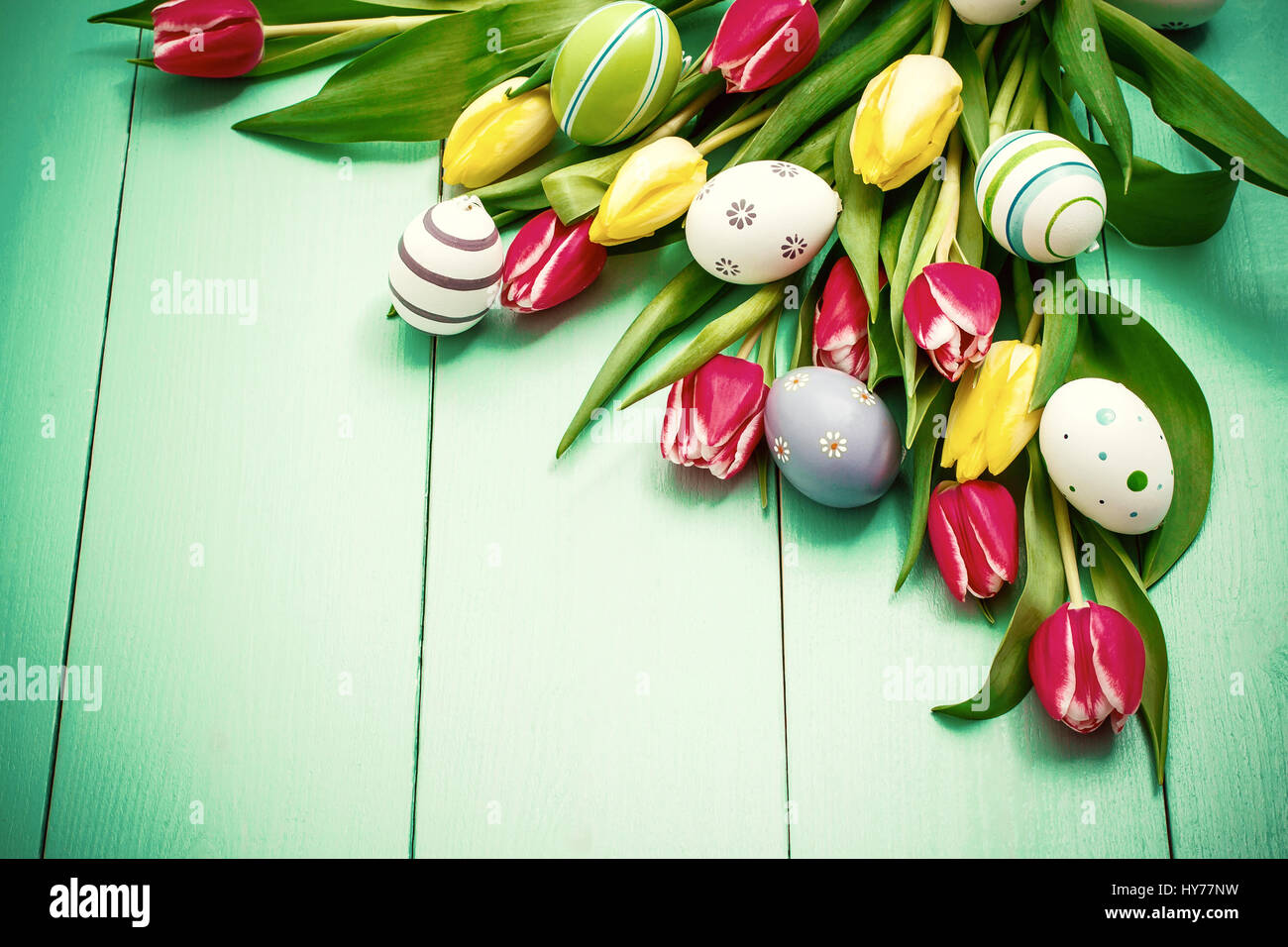 Rosso e tulipani gialli con colorate uova di Pasqua, vista dall'alto Foto Stock
