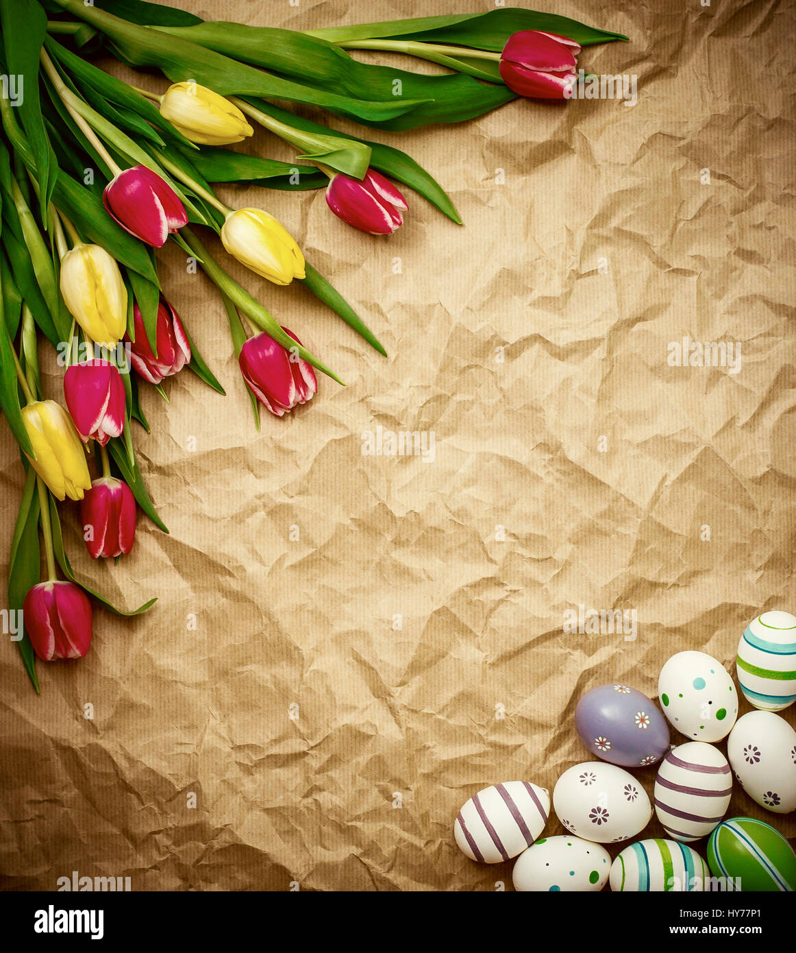 A poppavia di uova, tulipani su marrone crumpled carta di avvolgimento, vista dall'alto Foto Stock
