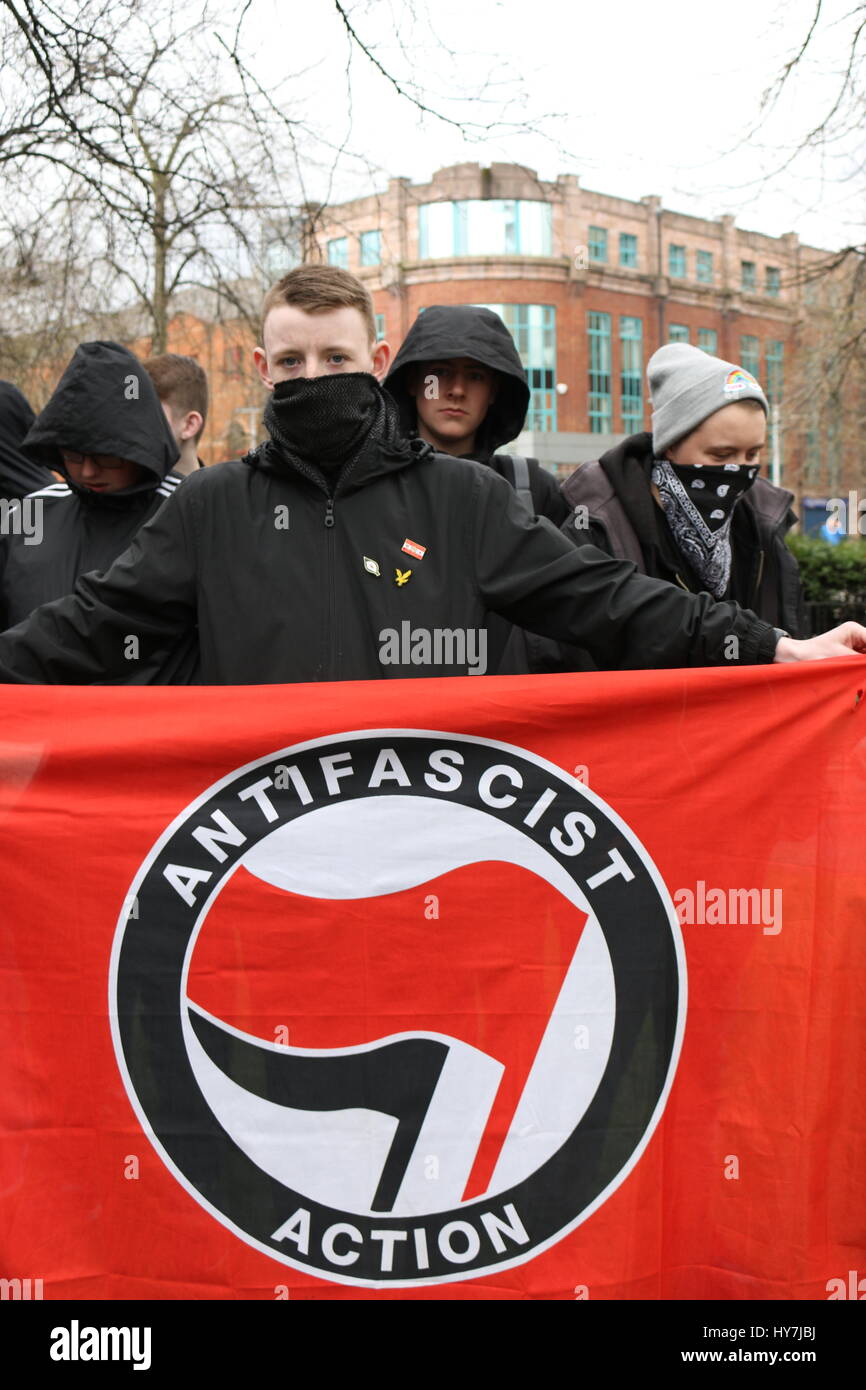 Belfast, Irlanda del Nord, Regno Unito. Il 1 aprile, 2017. Un manifestante mascherato visualizza un anti bandiera fascista durante una manifestazione di protesta a Belfast Credit: Conall Kearney/Alamy Live News Foto Stock