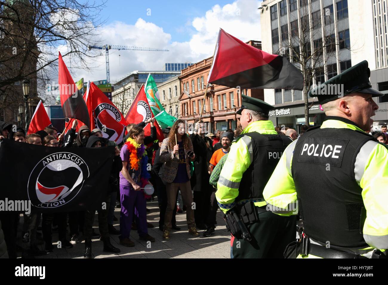 Belfast, Irlanda del Nord, Regno Unito. Il 1 aprile, 2017. Monitor di polizia una folla di anti manifestanti fascista al di fuori del Belfast City Hall Credito: Conall Kearney/Alamy Live News Foto Stock