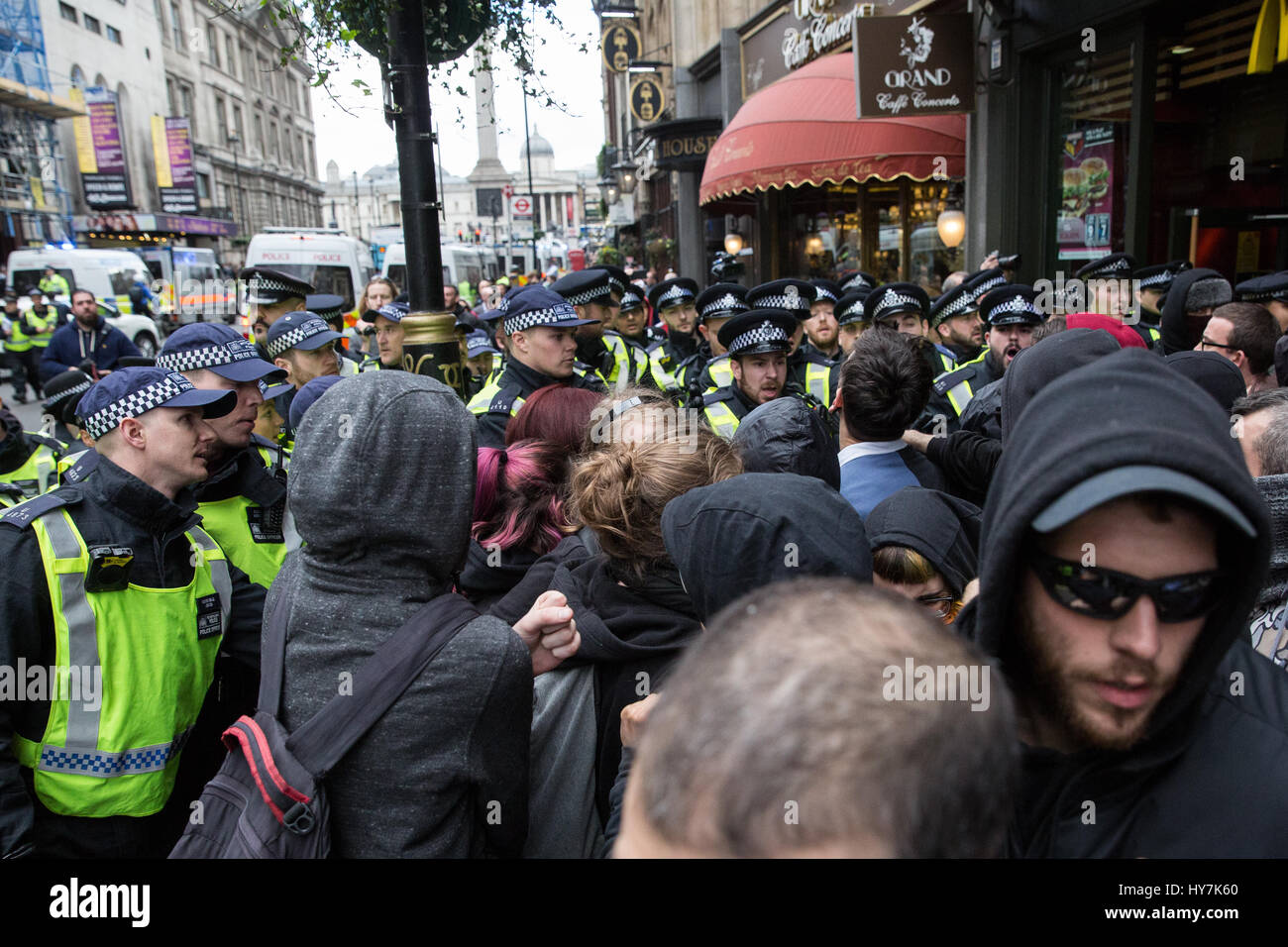 Londra, Regno Unito. Il 1 aprile, 2017. Gli ufficiali di polizia si muovono i sostenitori di unirsi contro il fascismo e altri gruppi antifascisti lungo Whitehall lontano da un pub occupato dai membri di estrema destra della Difesa inglese League. Credito: Mark Kerrison/Alamy Live News Foto Stock