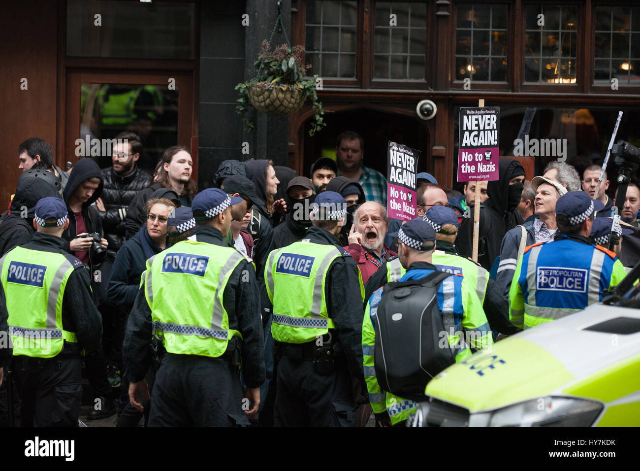 Londra, Regno Unito. Il 1 aprile, 2017. Gli ufficiali di polizia si muovono i sostenitori di unirsi contro il fascismo e altri gruppi antifascisti lungo Whitehall lontano da un pub occupato dai membri di estrema destra della Difesa inglese League. Credito: Mark Kerrison/Alamy Live News Foto Stock
