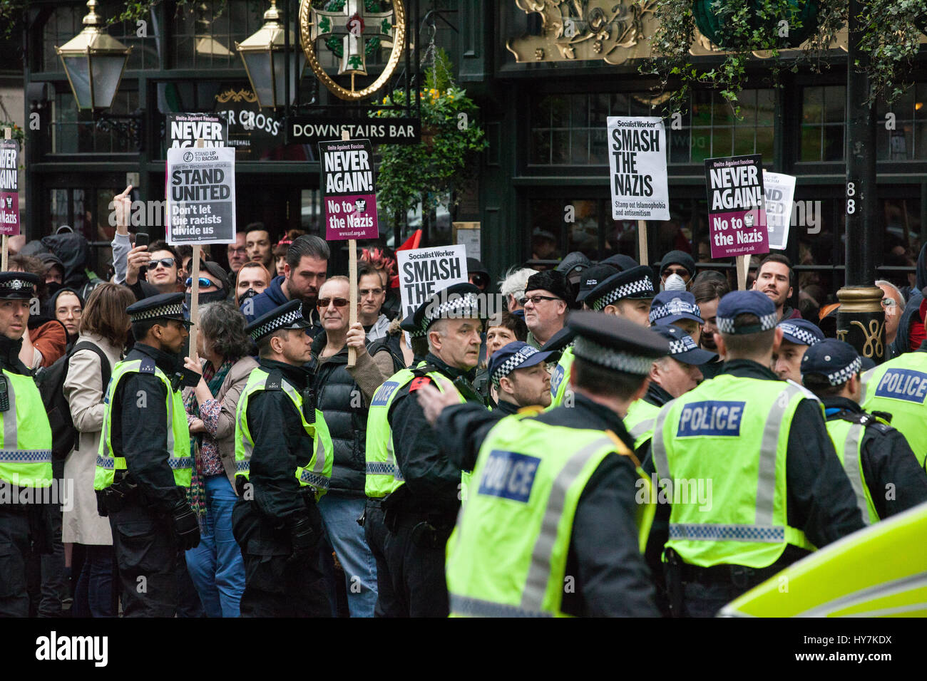 Londra, Regno Unito. Il 1 aprile, 2017. Gli ufficiali di polizia sotto forma di un cordone intorno i sostenitori di unirsi contro il fascismo e altri gruppi antifascisti protestare di fronte un pub occupato dai membri di estrema destra della Difesa inglese League. Credito: Mark Kerrison/Alamy Live News Foto Stock