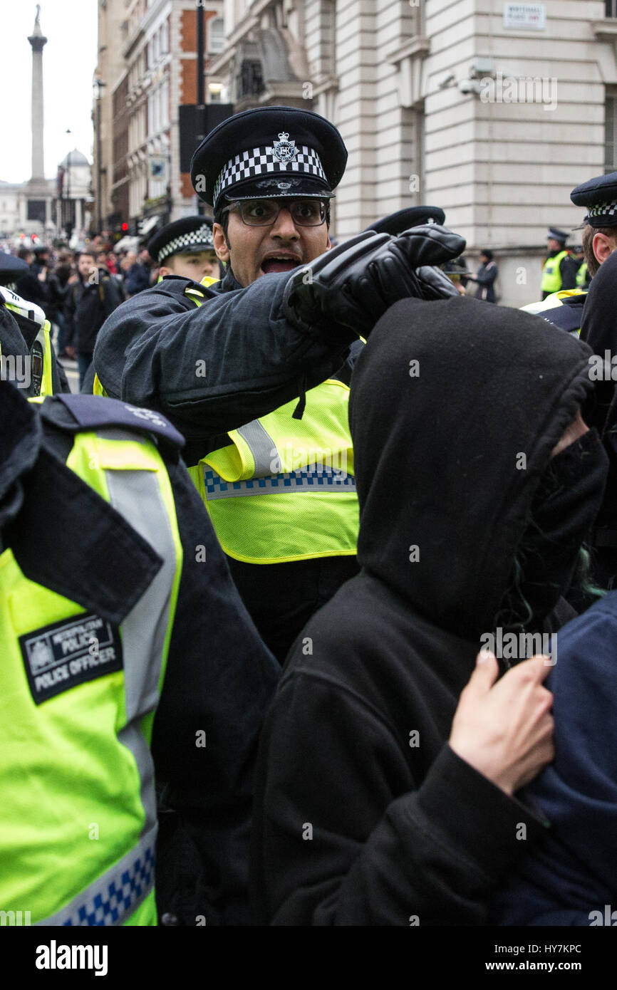 Londra, Regno Unito. Il 1 aprile, 2017. Gli ufficiali di polizia si muovono i sostenitori di unirsi contro il fascismo e altri gruppi antifascisti lungo Whitehall lontano da un pub occupato dai membri di estrema destra della Difesa inglese League. Credito: Mark Kerrison/Alamy Live News Foto Stock