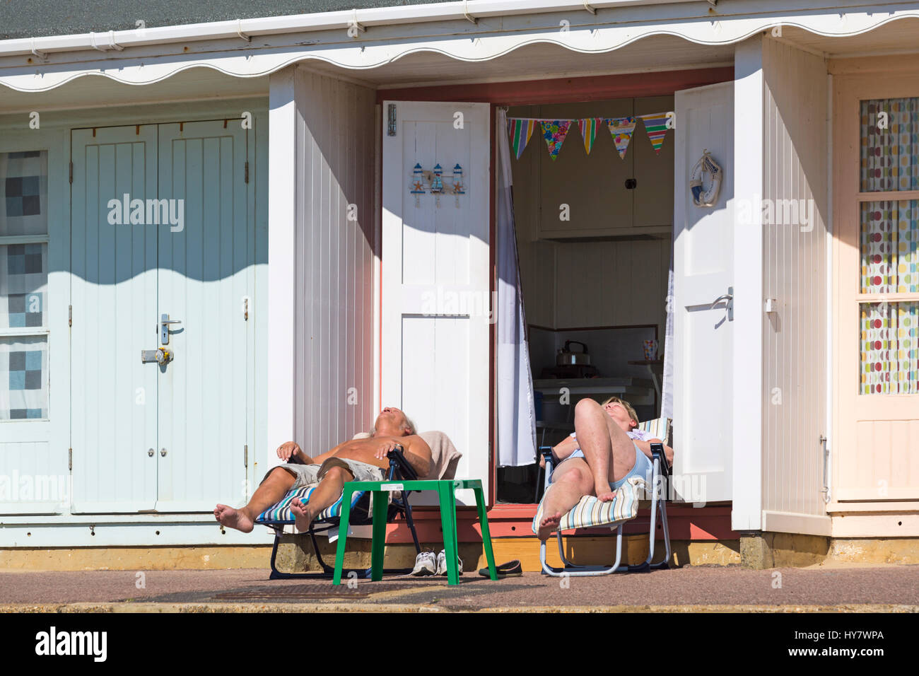 Bournemouth Dorset, Regno Unito. Il 2 aprile 2017. Regno Unito: meteo bella calda giornata di sole come testa di visitatori al mare per rendere la maggior parte del sole a Bournemouth spiagge. Giovane sulle sedie a sdraio fuori beach hut a prendere il sole e godersi il sole. Credito: Carolyn Jenkins/Alamy Live News Foto Stock