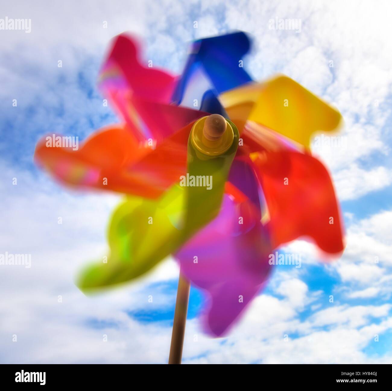 Colorate il mulino a vento di giocattolo contro il sole e un cielo blu. Foto Stock