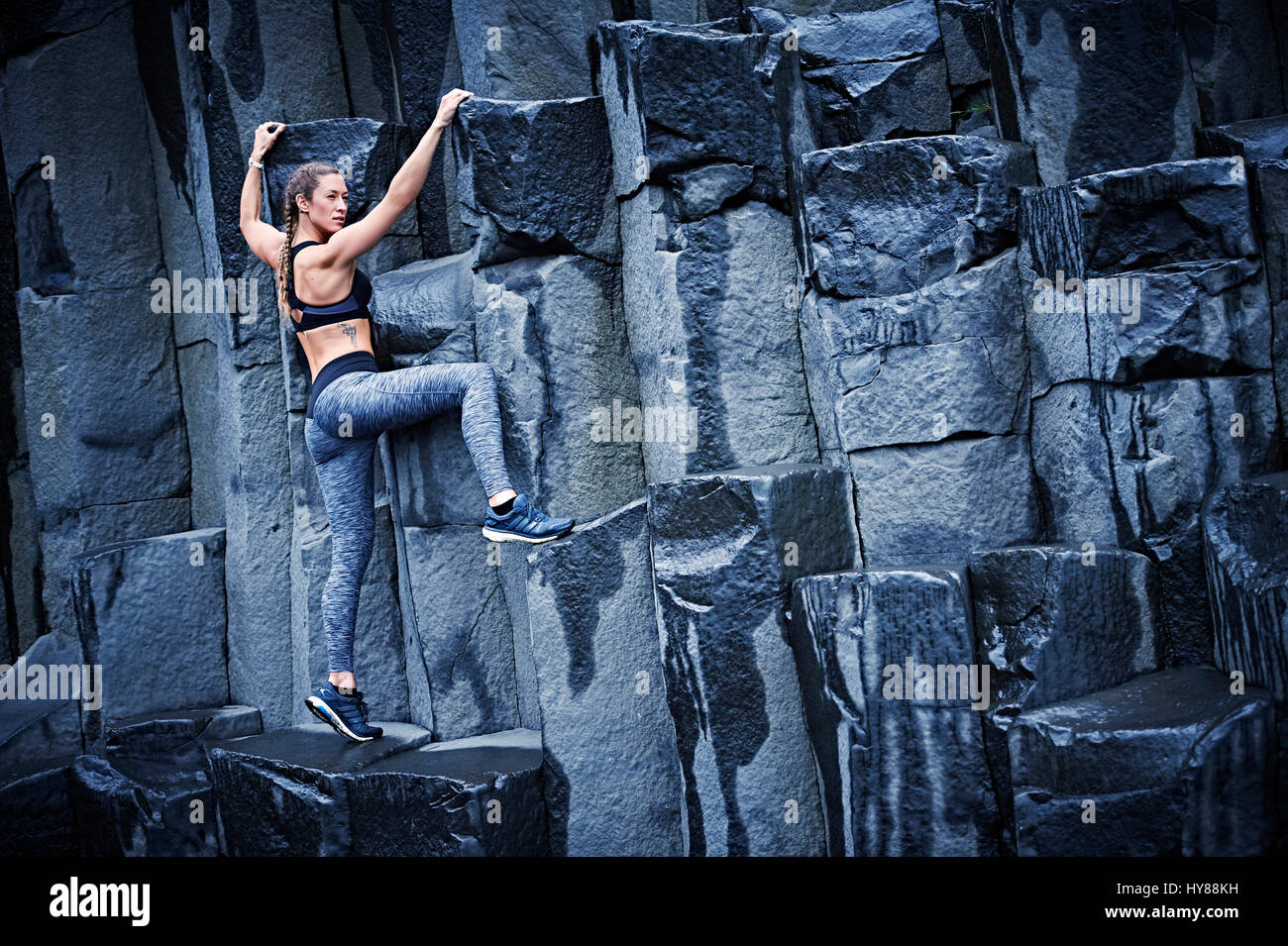 Felice fiducioso giovani donne di arrampicata su roccia di basalto nel sud dell'Islanda Foto Stock