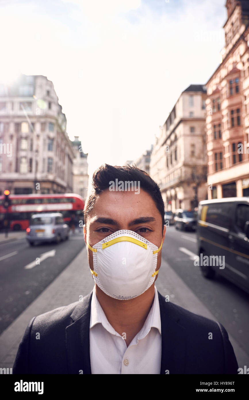 Un giovane uomo giapponese indossa una maschera filtrante a Londra Foto Stock