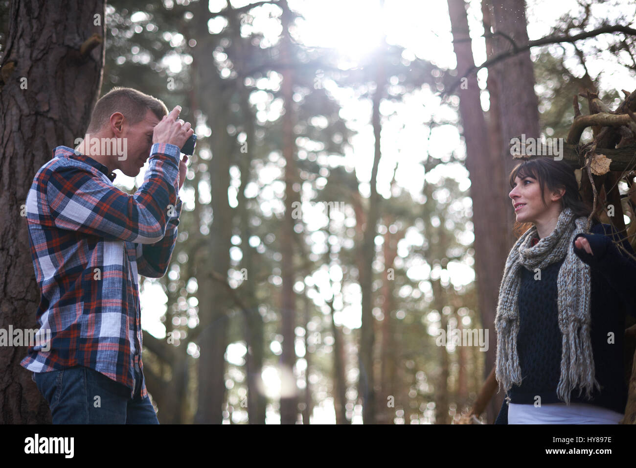 Un uomo prende una foto del suo compagno femminile come la passeggiata nel bosco Foto Stock