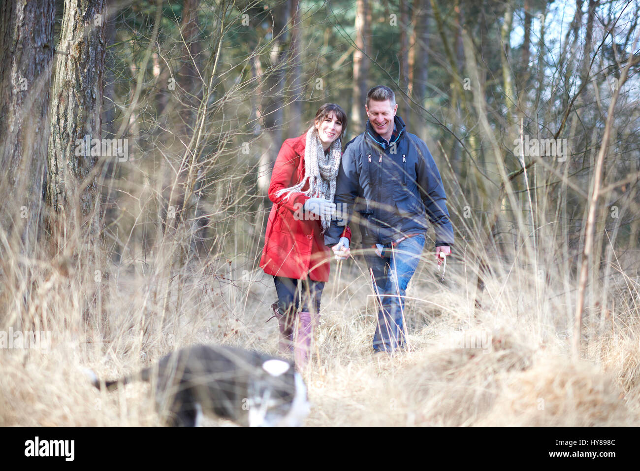 Una giovane coppia camminare mano nella mano nel bosco Foto Stock