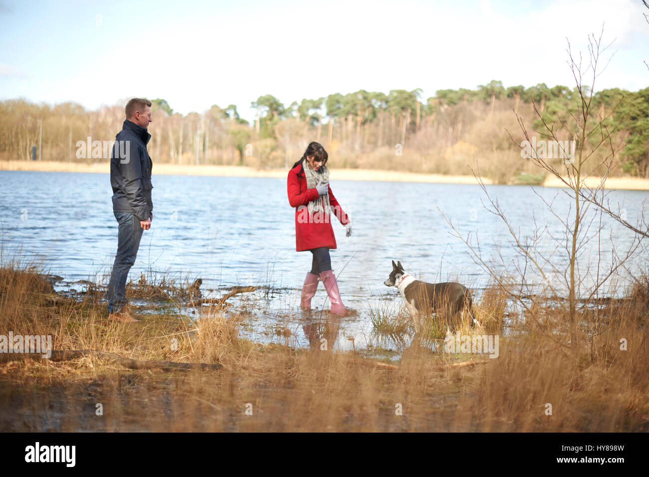 Una giovane coppia in una passeggiata nei boschi da un lago Foto Stock