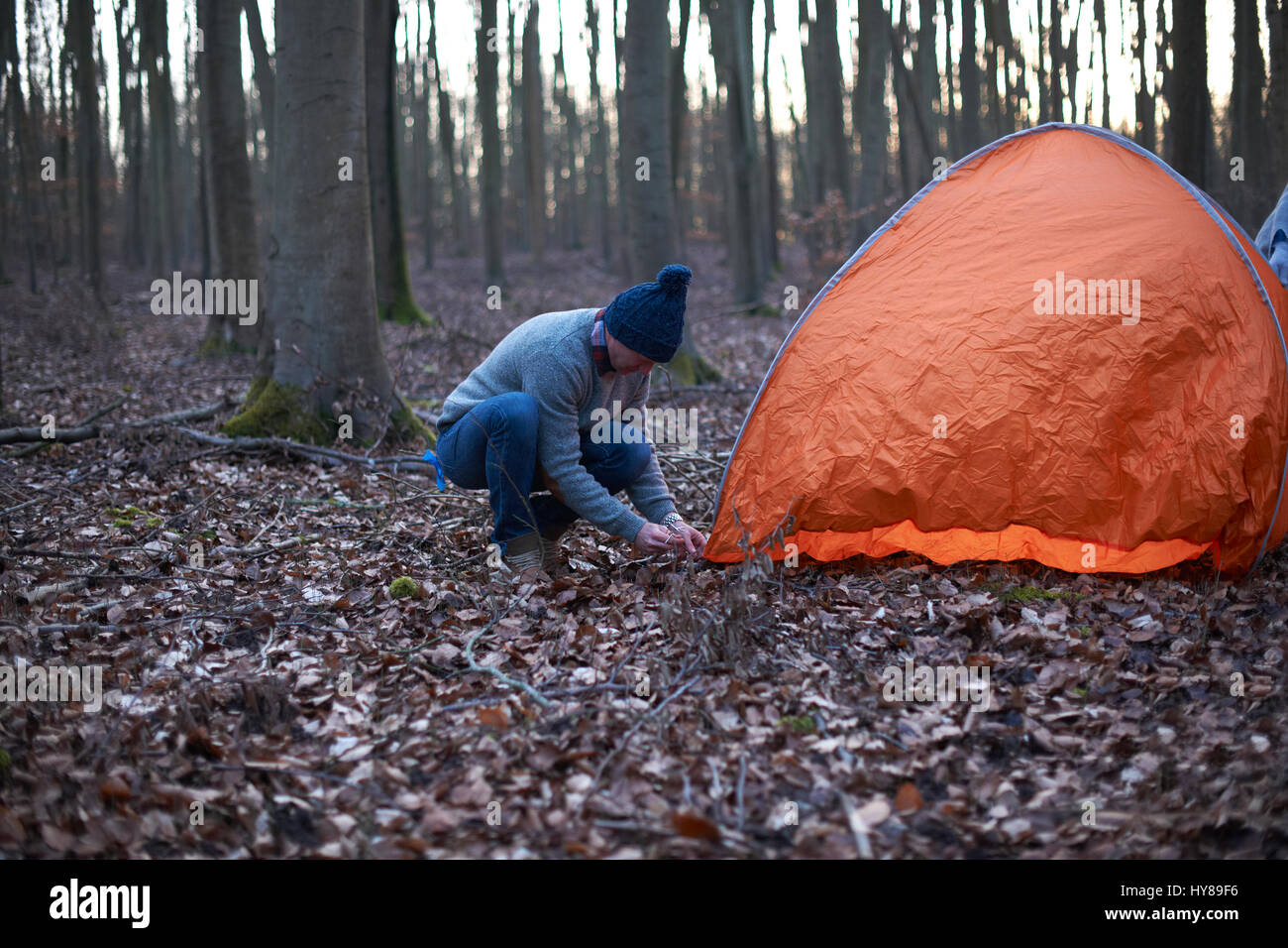 Un uomo mette una tenda nel bosco Foto Stock