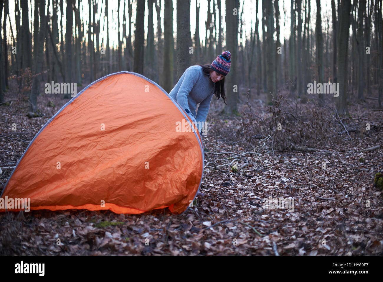 Una donna mette una tenda nel bosco Foto Stock