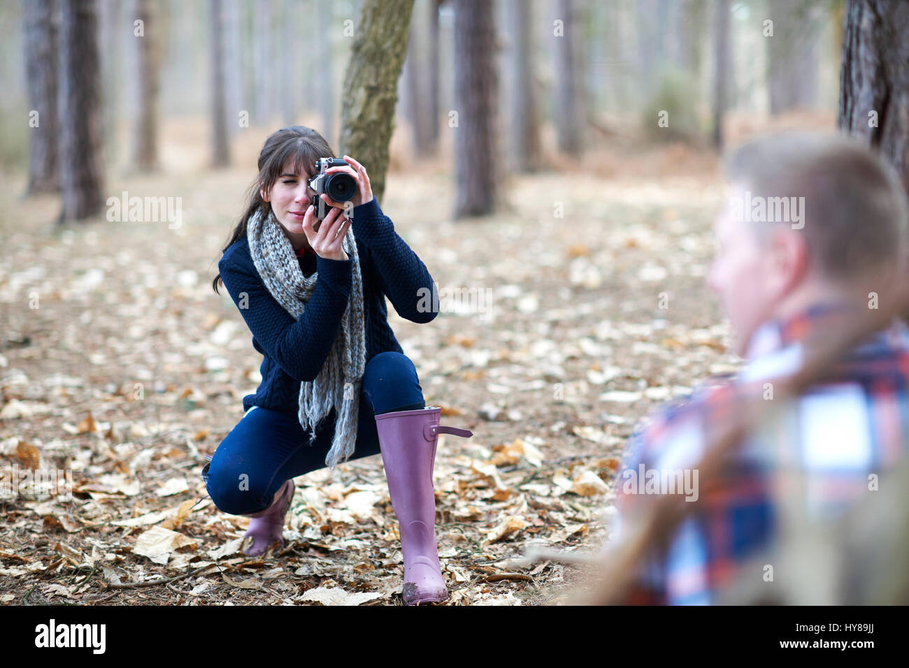 Una giovane donna assume una foto del suo partner nel bosco Foto Stock