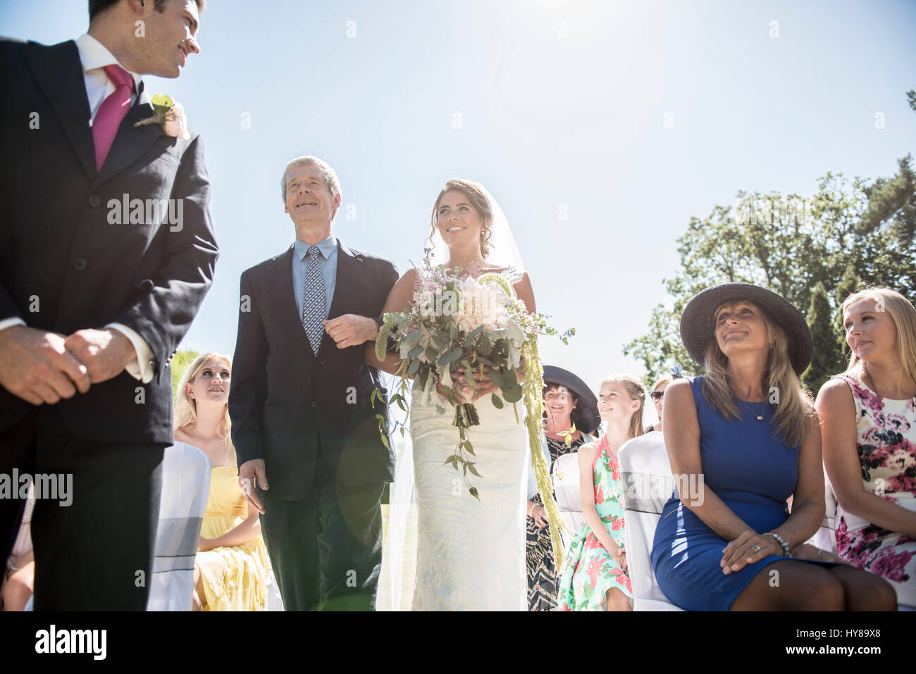 Un orgoglioso padre accompagna la sua figlia all'isola sul suo giorno di nozze Foto Stock