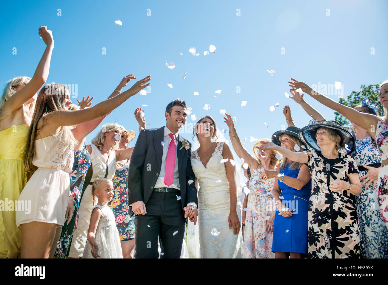 La sposa e lo sposo sono salutati con i confetti il giorno delle nozze Foto Stock