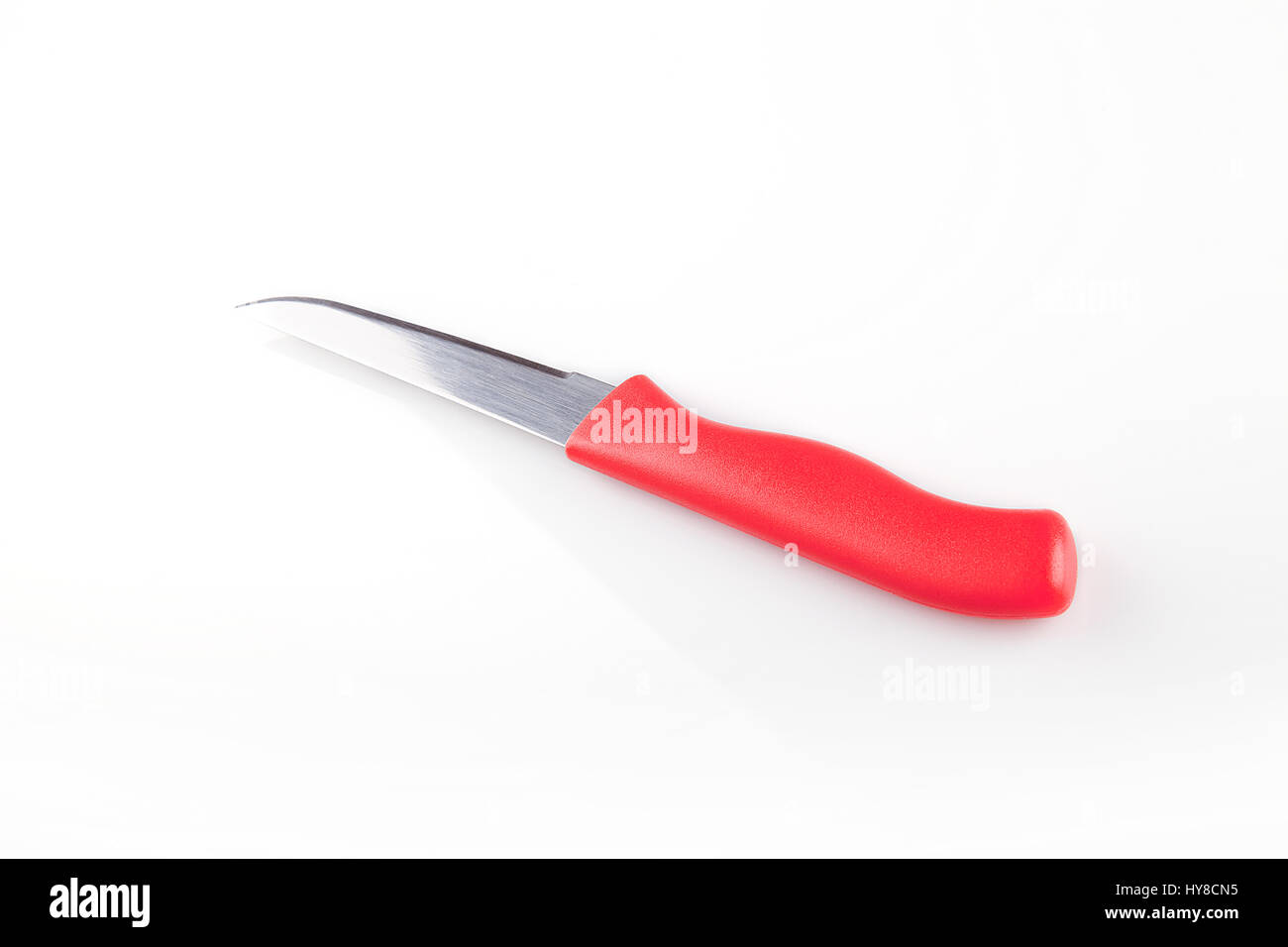 Red coltello da cucina su una superficie bianca. Utensile da cucina isolati su sfondo bianco. Foto Stock