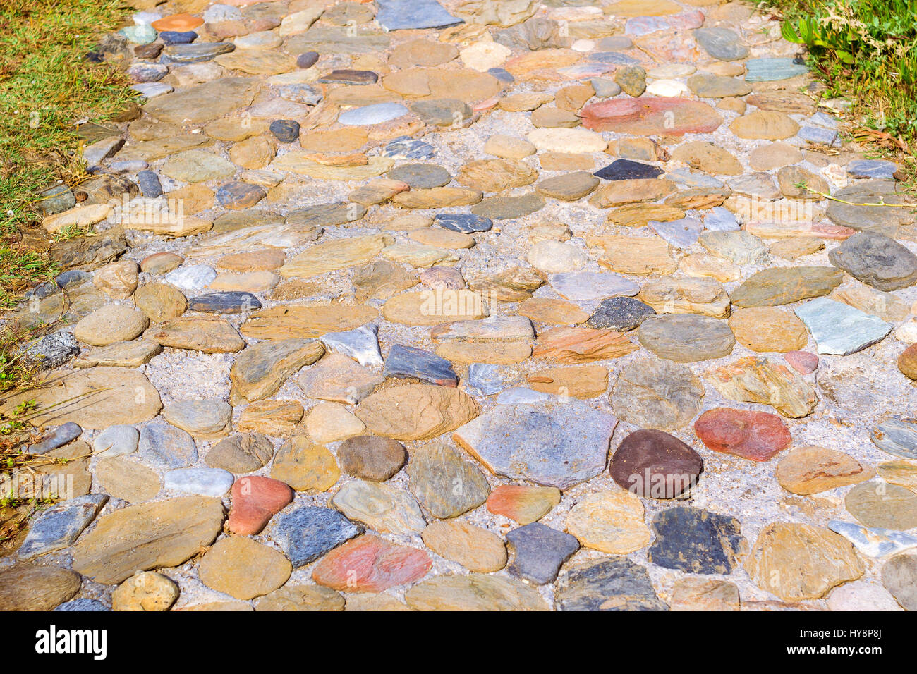 Percorso pedonale lastricata di pietra in granito. Texture della pietra naturale. Villaggio Bali, Creta, Grecia Foto Stock