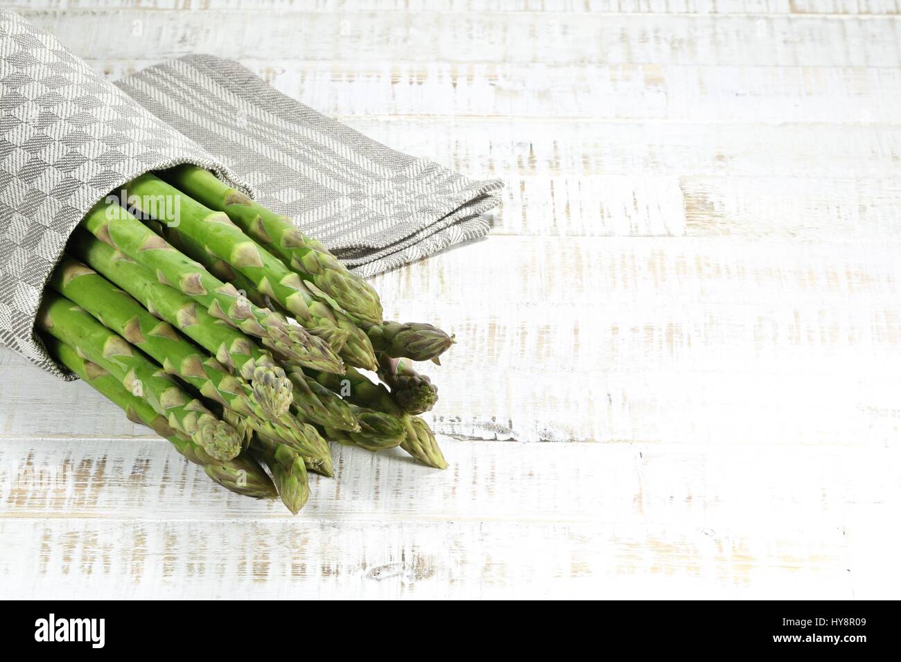 Bundle di asparagi verdi su sfondo di legno Foto Stock