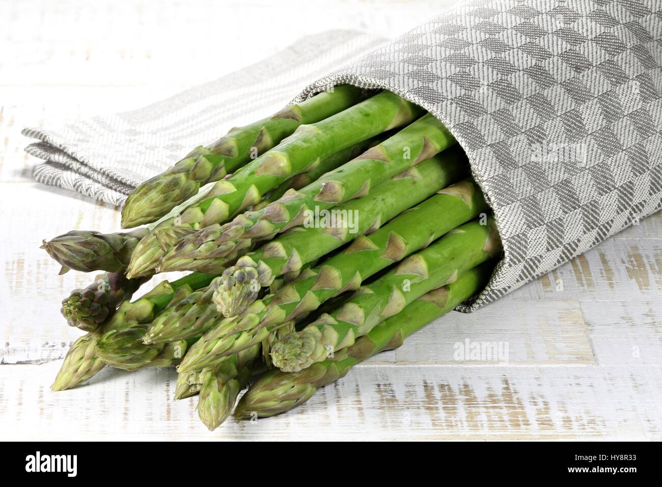 Bundle di asparagi verdi su sfondo di legno Foto Stock