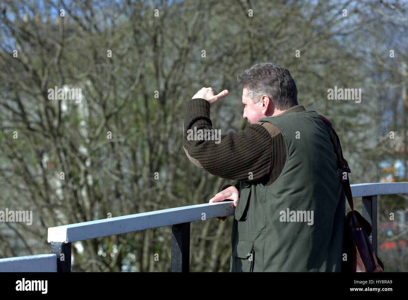 Vestito per esterni uomo protezioni ad occhi egli guarda dal ponte Foto Stock