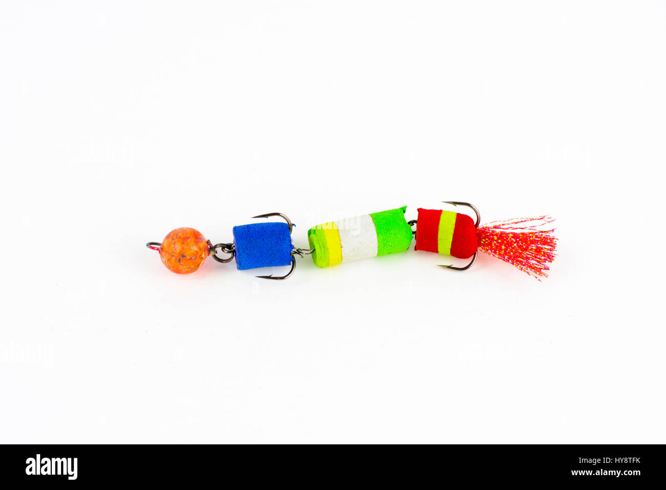 Mostra di self-made pesca esche di metallo. Esca per la pesca a forma di cucchiaio con un gancio su uno sfondo bianco. Foto Stock